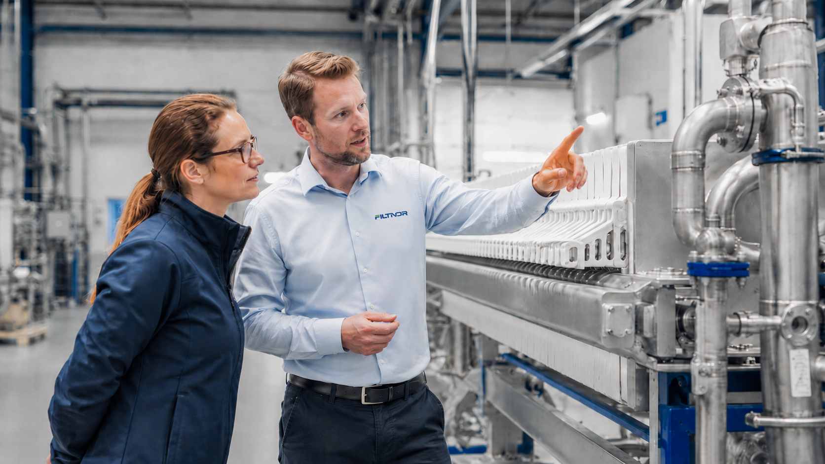 Industrial Filtration Support from Filtnor Filtnor engineer discussing an industrial filter press with a customer